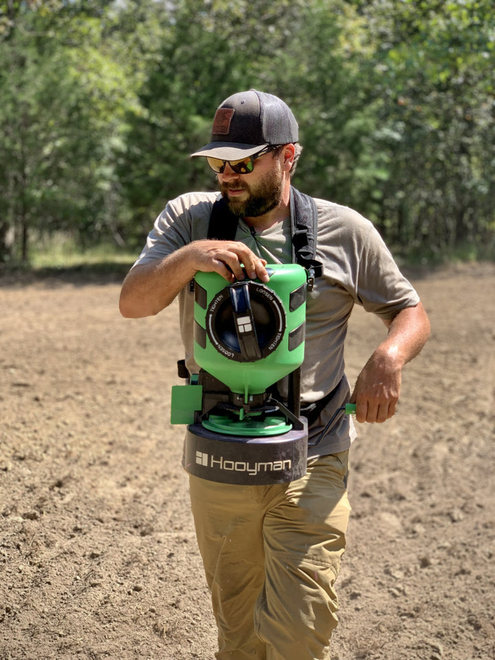 Hunter using the Hooyman manual chest spreader on a food plot