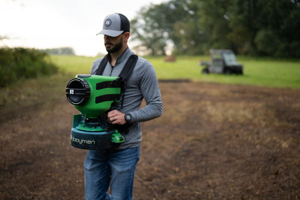 Hooyman 24V chest spreader broadcasting seed on a food plot