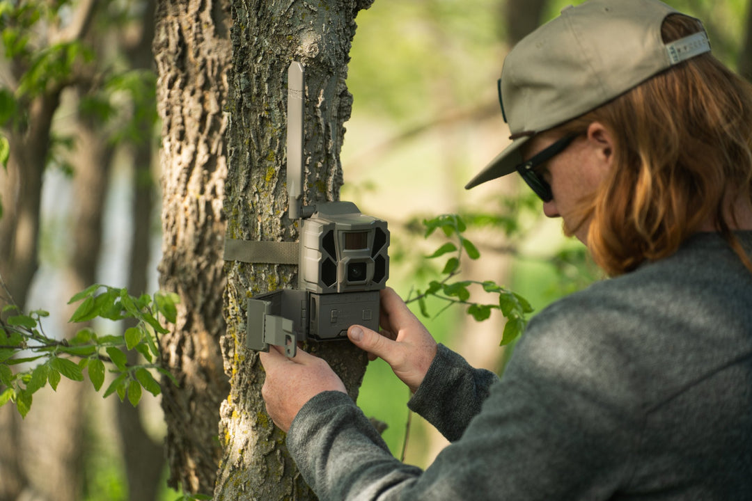 Hunter mounting a REVEAL X 3.0 on a tree