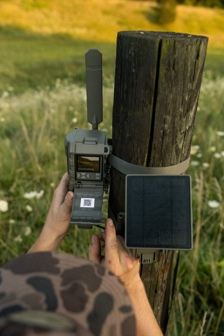 Hunter setting up the REVEAL Pro 4.0 Solar on a fence post